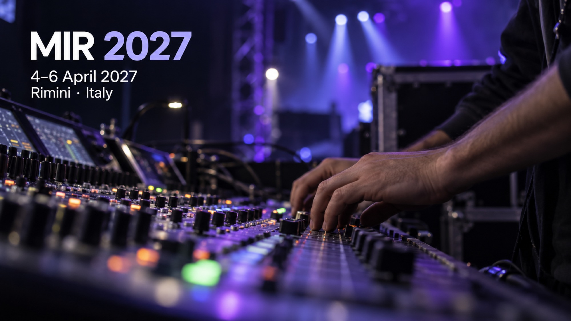 A sound engineer adjusts a production mixing console under blue and violet stage lighting.
