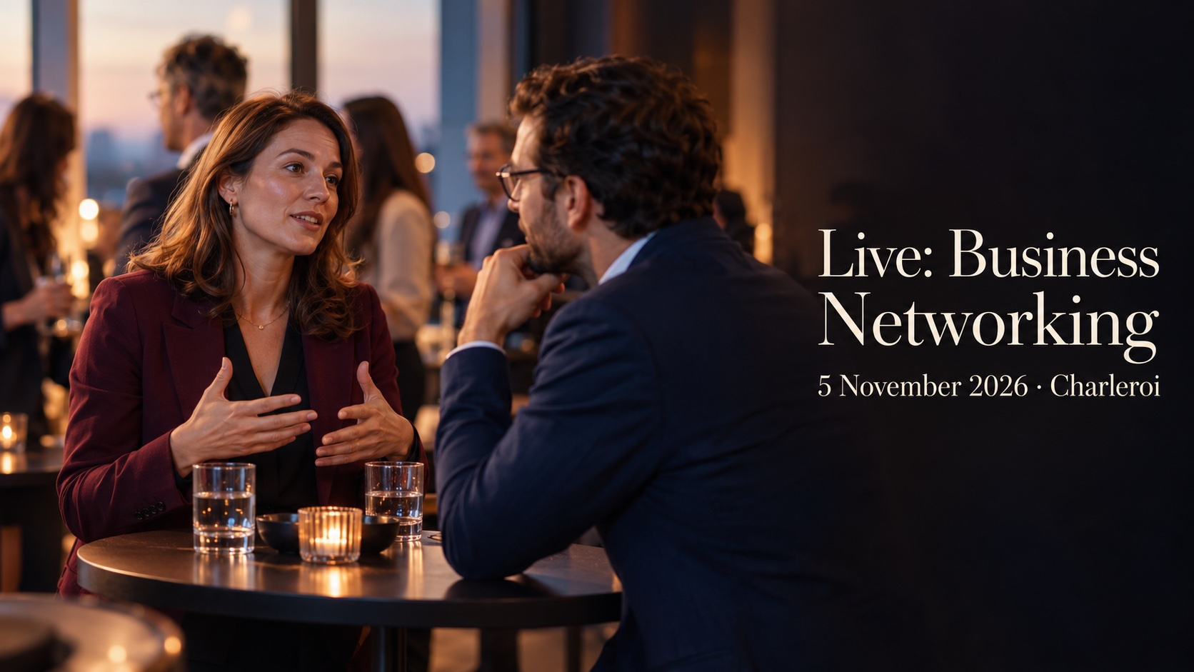 Two professionals talk across a small table at an evening business gathering.