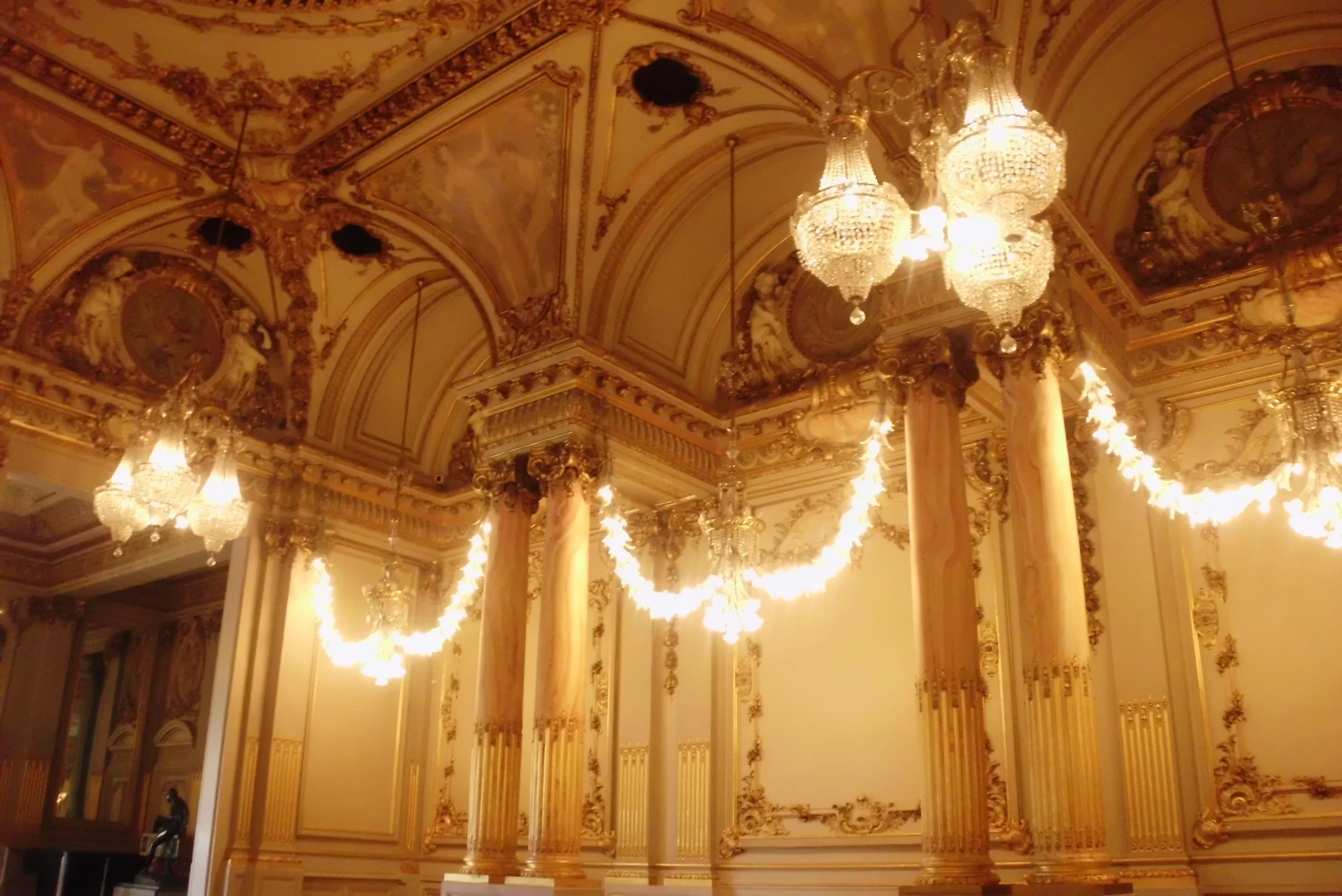 Chandeliers, gilded wall details and a painted ceiling in the Salle des fêtes at Musée d’Orsay.