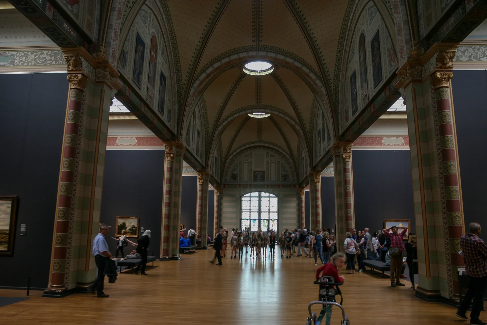 Visitors beneath the decorated vaulted ceiling of the Rijksmuseum’s Gallery of Honour.