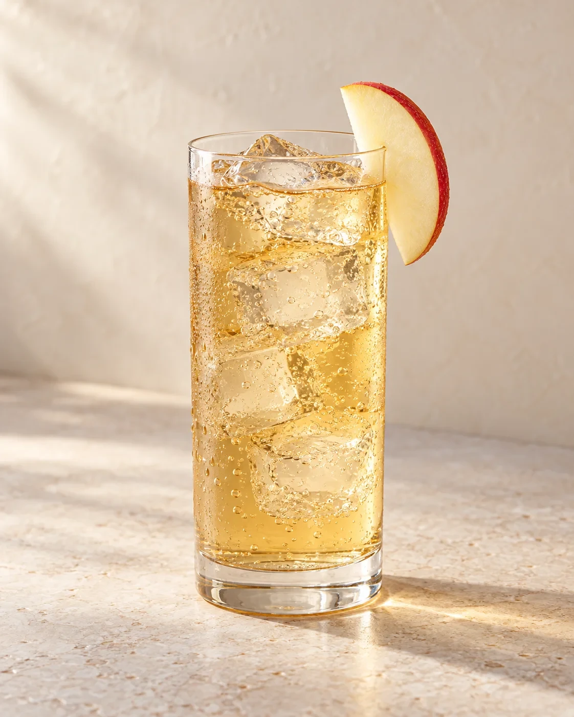 AI concept of a pale golden drink in a highball glass with ice and one thin red-skinned apple slice on the rim.